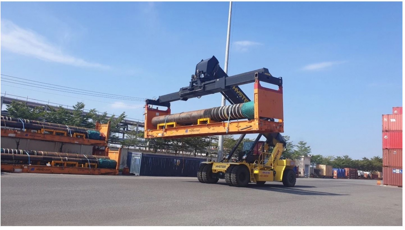 A large piece of industrial machinery being loaded onto a specialized transport vessel for Project and Oversized Cargo.